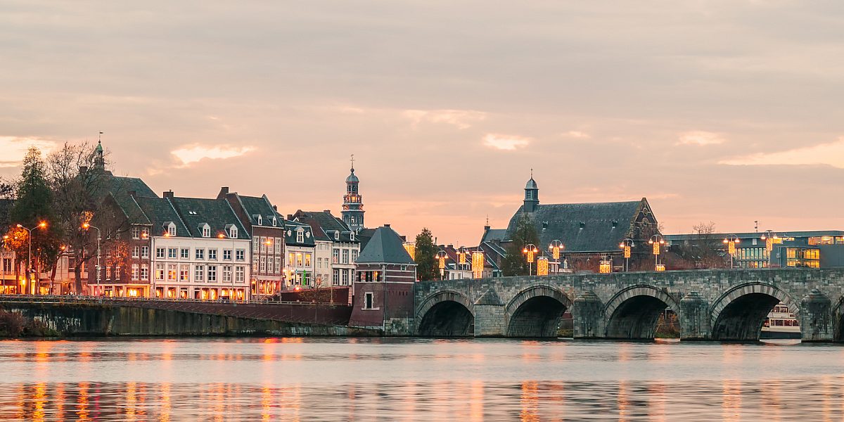 Panoramic view at the famous Dutch Sint Servaas bridge with lights in the city center of Maastricht
