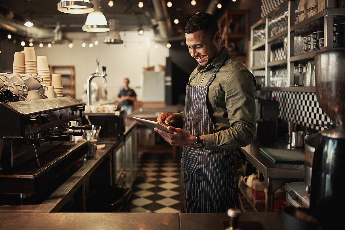 Barman kijkt blij naar iPad