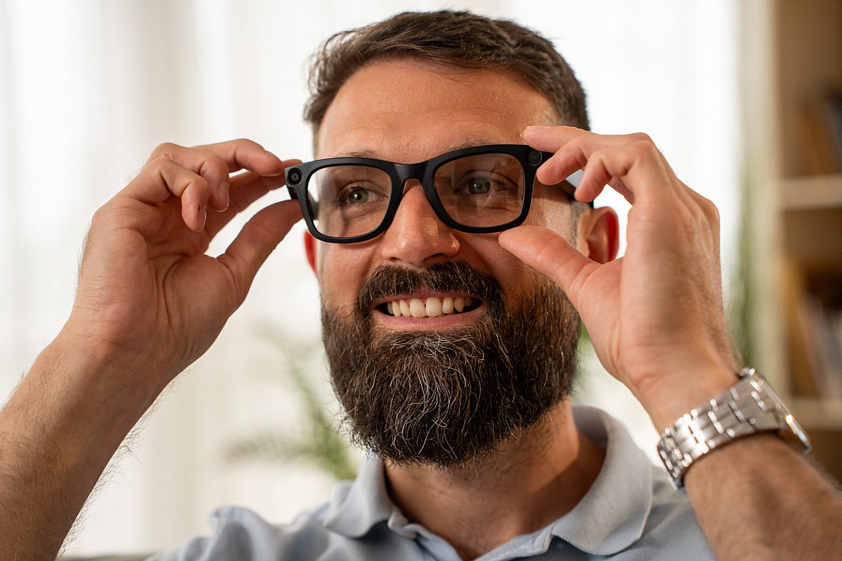 Young man wearing AR smart glasses exploring digital innovation, augmented reality and futuristic technology