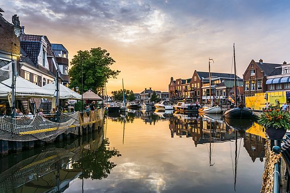 Lemmer, Netherlands - August 15, 2022: View of a water canal in the city of Lemmer in Friesland, Netherlands in beautiful sunset light