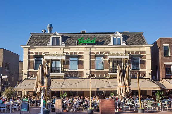 People sitting and drinking in the spring sun at a cafe in Almelo, Netherlands