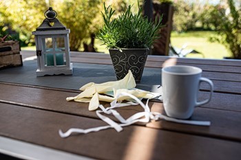 Mondkapje op terras tafeltje naast mok