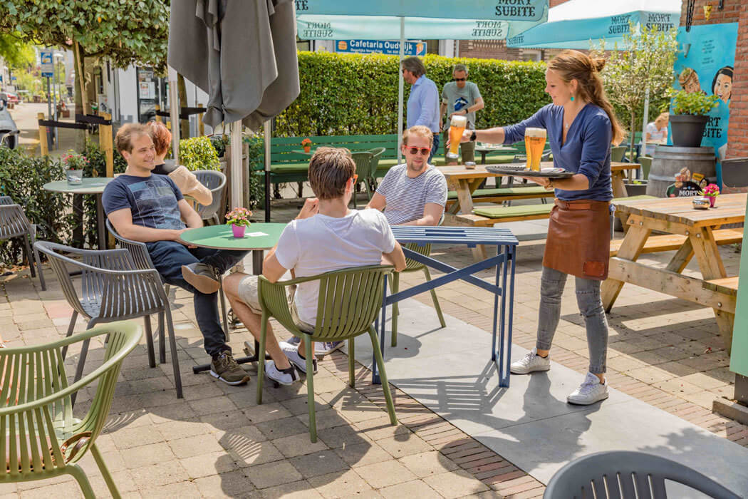 Terras met jongeren op 1,5 meter zonnig bier geserveerd
