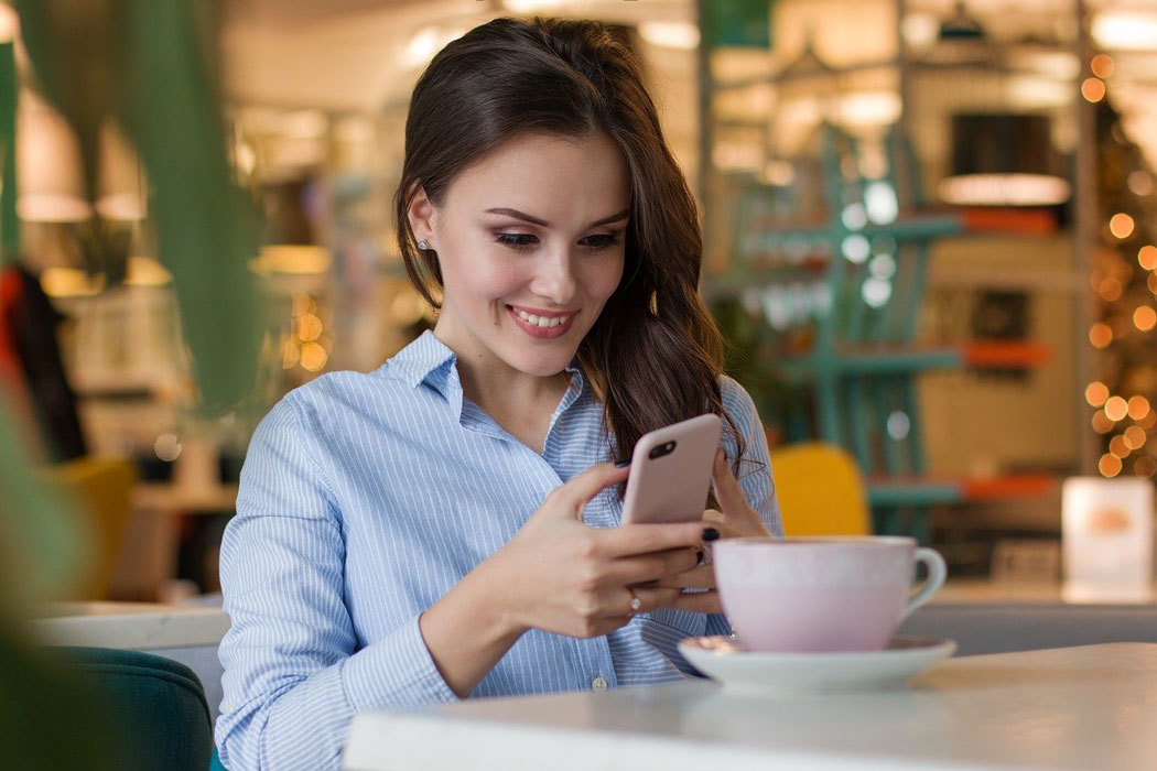 Vrouw koffie smartphone binnen restaurant
